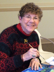 Photo of Anne Hanna painting in her studio